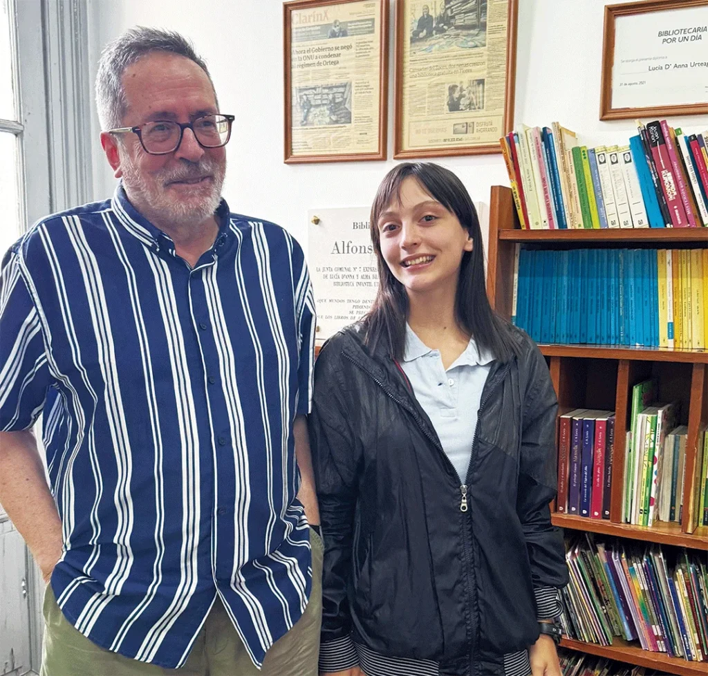 Lucía D´Anna Urteaga es vecina de Flores y escribe cuentos en Flores de Papel desde 2021. En la imagen, junto a César Aira en la Biblioteca Infantil "Alfonsina Storni" del Museo Barrio de Flores.