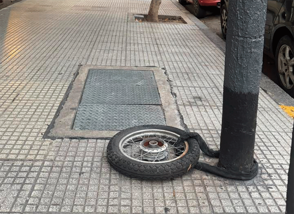 En la esquina de Falcón y Rivera Indarte, la inseguridad se manifiesta con una modalidad que expone la impunidad en las calles del barrio. Una rueda delantera atada con cadena y candado a un poste de luz es lo único que quedó de la moto de un vecino. Del resto del vehículo no hay rastros: se lo llevaron, dejando únicamente la rueda enganchada.